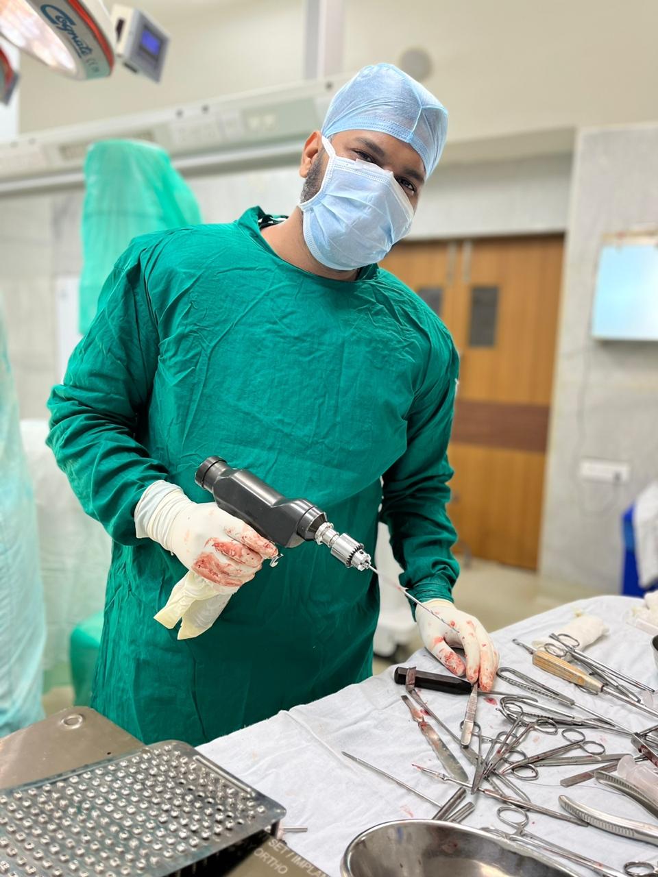Dr. Sunil using a powered orthopedic drill during a procedure